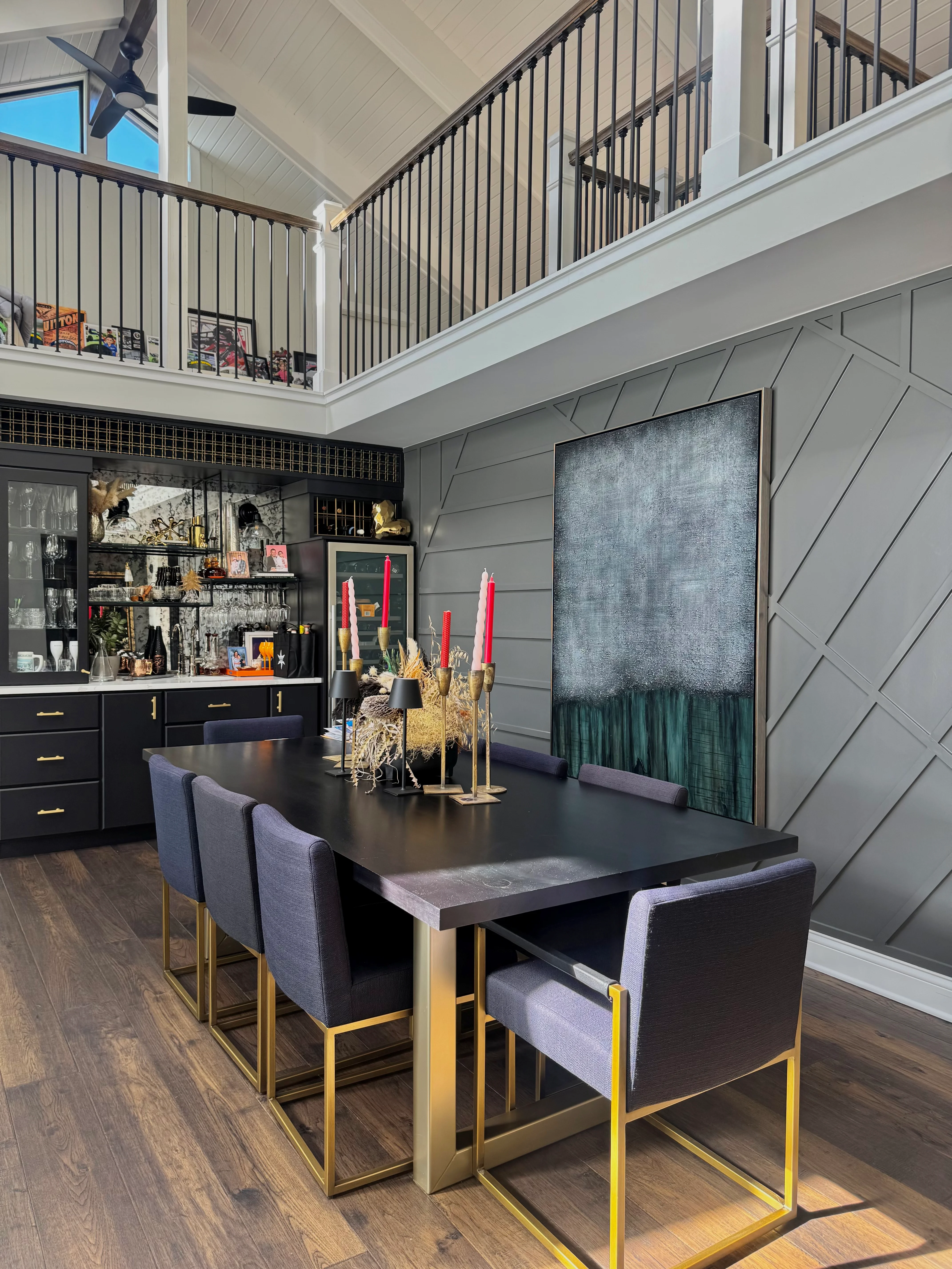 Modern loft interior with gray shiplap walls, black cabinetry, brass railings, and hardwood flooring