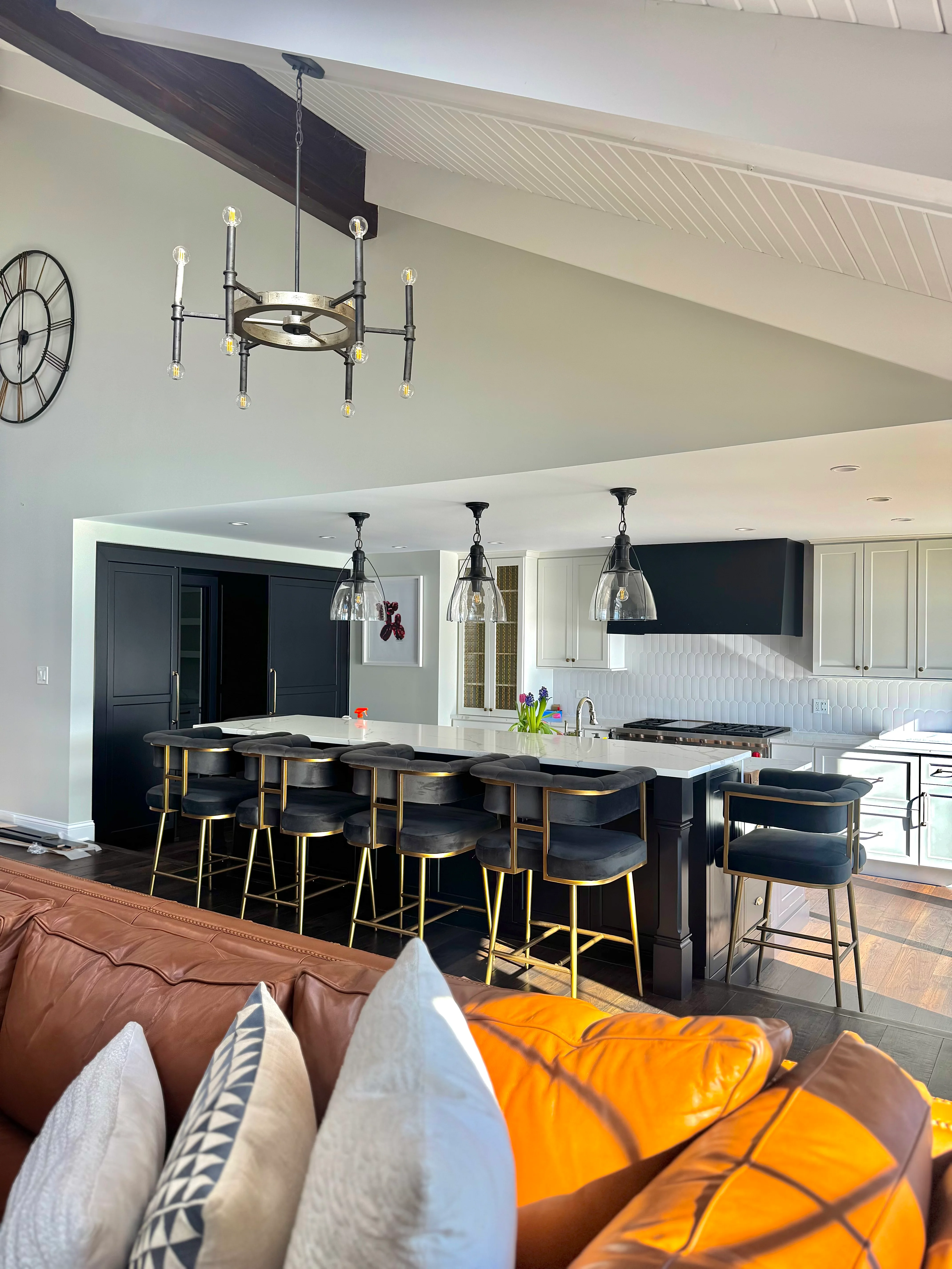 Modern kitchen with black cabinetry, white countertops, and pendant lighting in open-concept home
