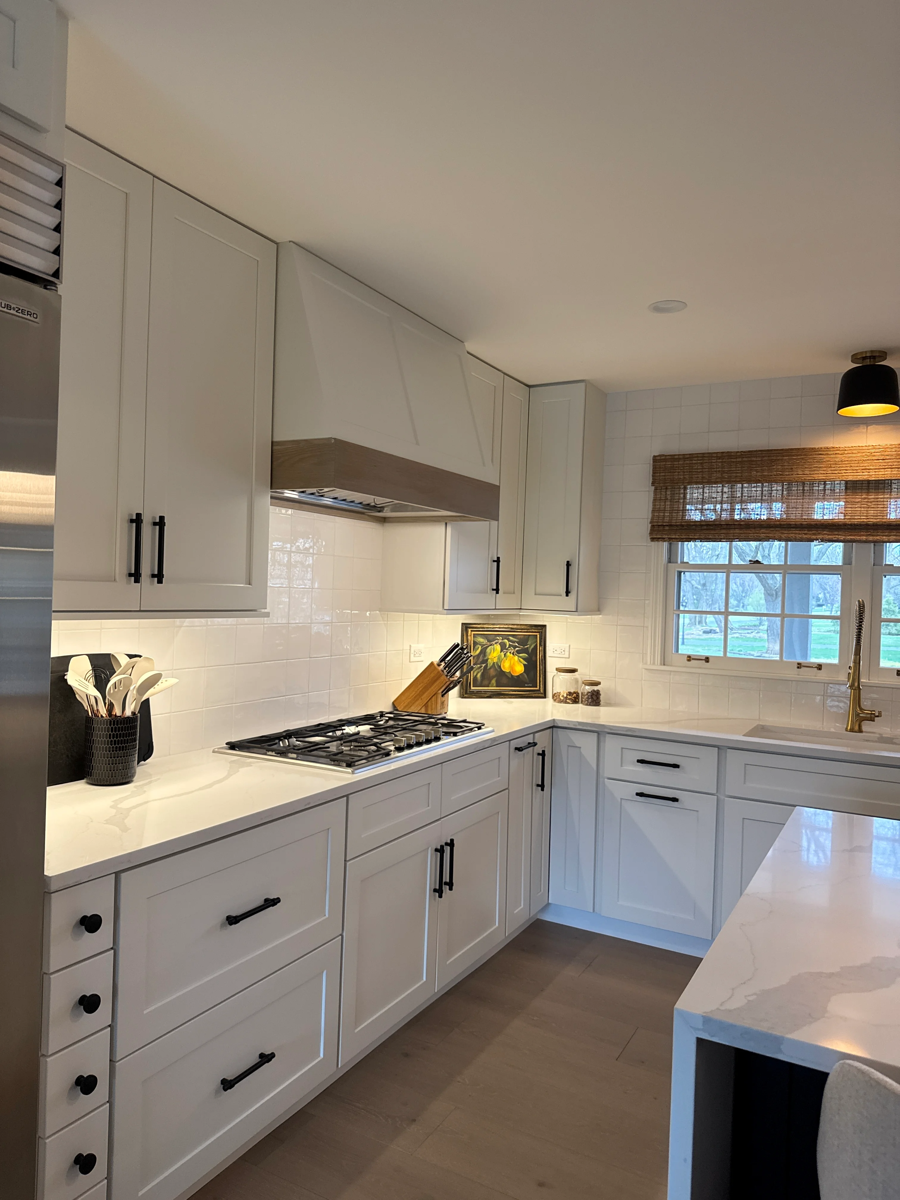 White kitchen with shaker cabinets, quartz counters, subway tile backsplash, and gas cooktop