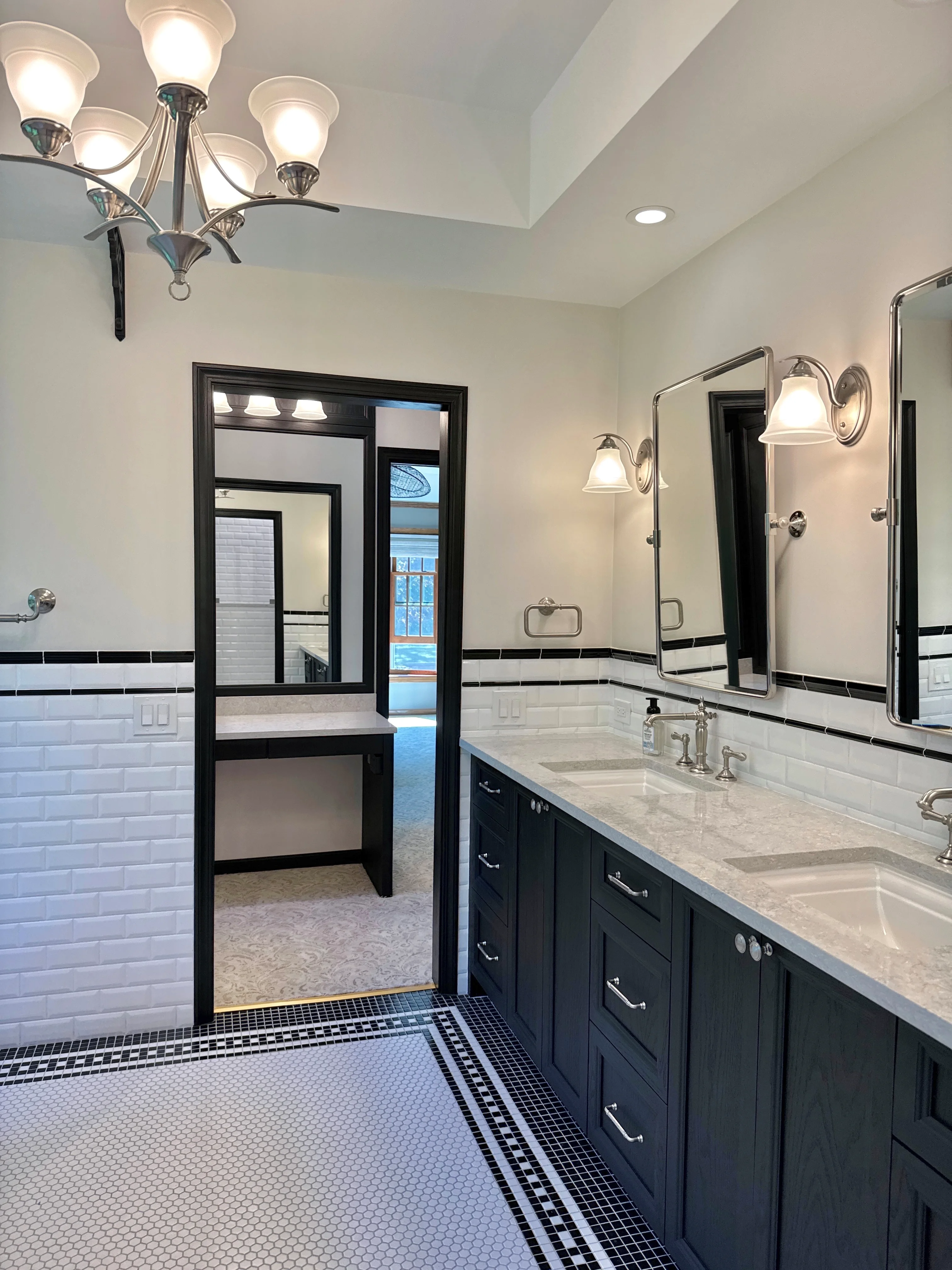Master bathroom with white subway tile, black accents, marble counters, dual vanities, and glass shower enclosure