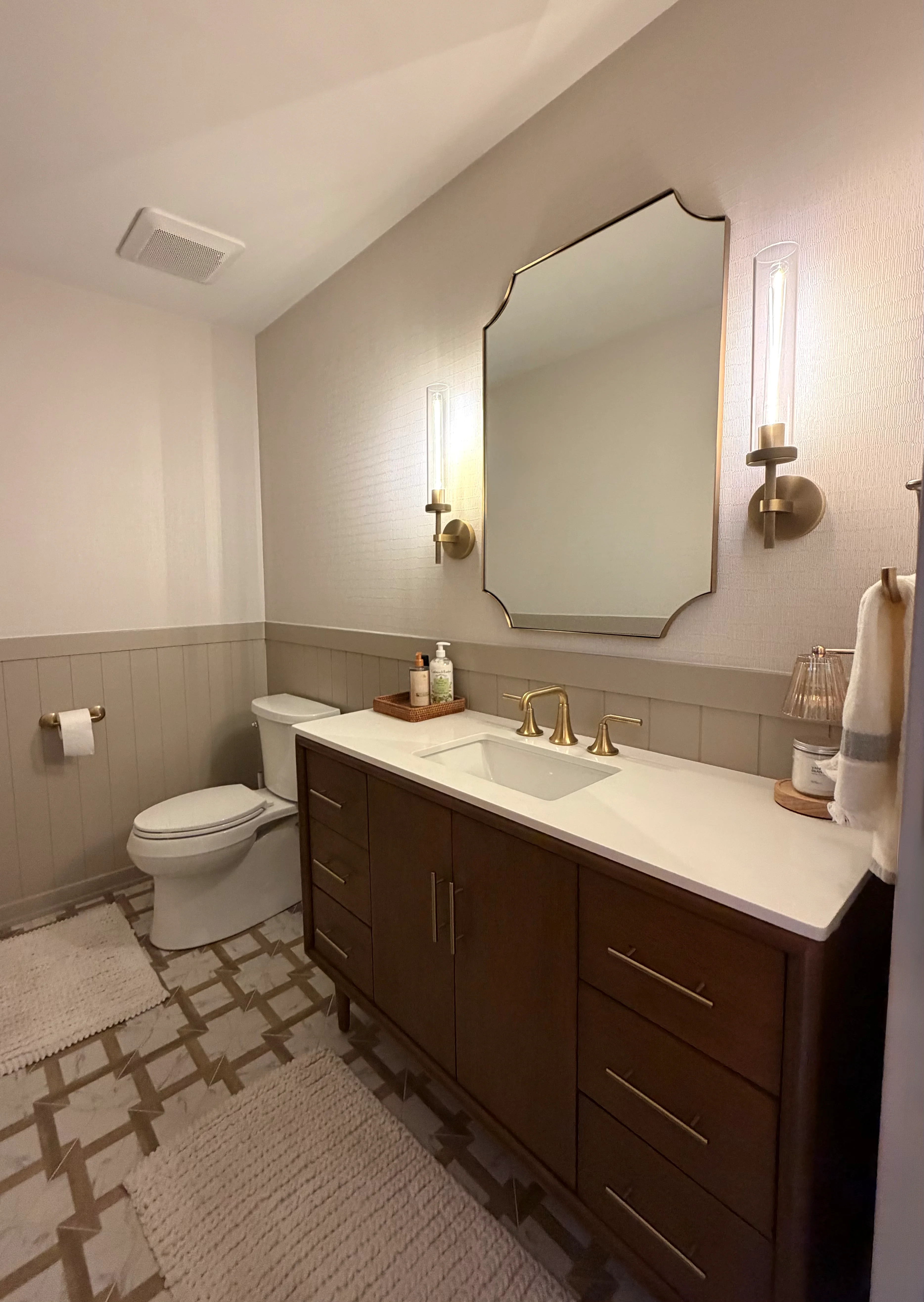 Bathroom with dark wood vanity, white quartz countertop, shiplap wainscoting, and geometric tile flooring