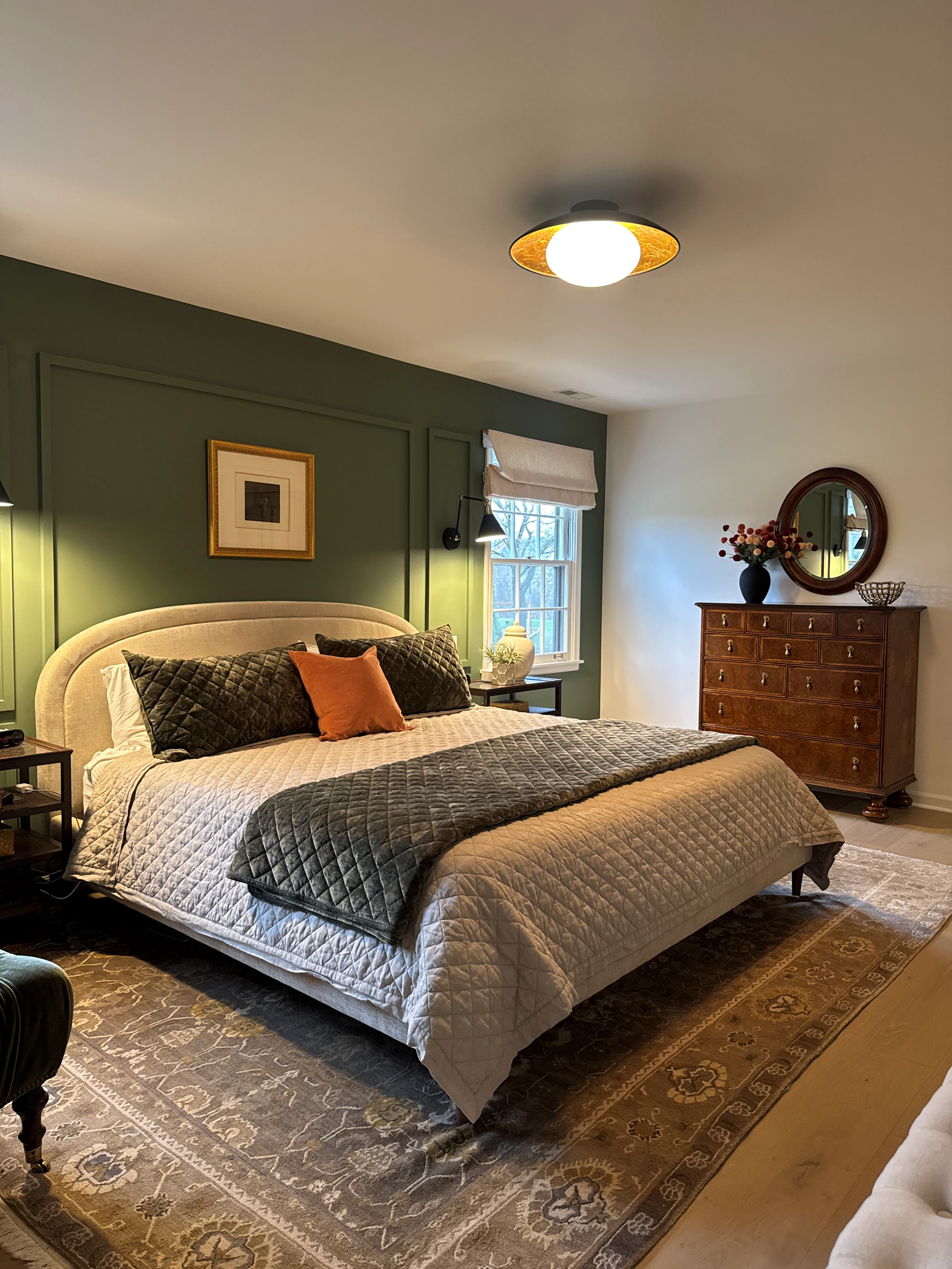 Master bedroom with sage green shiplap wall, cream upholstered bed, hardwood flooring, and recessed lighting