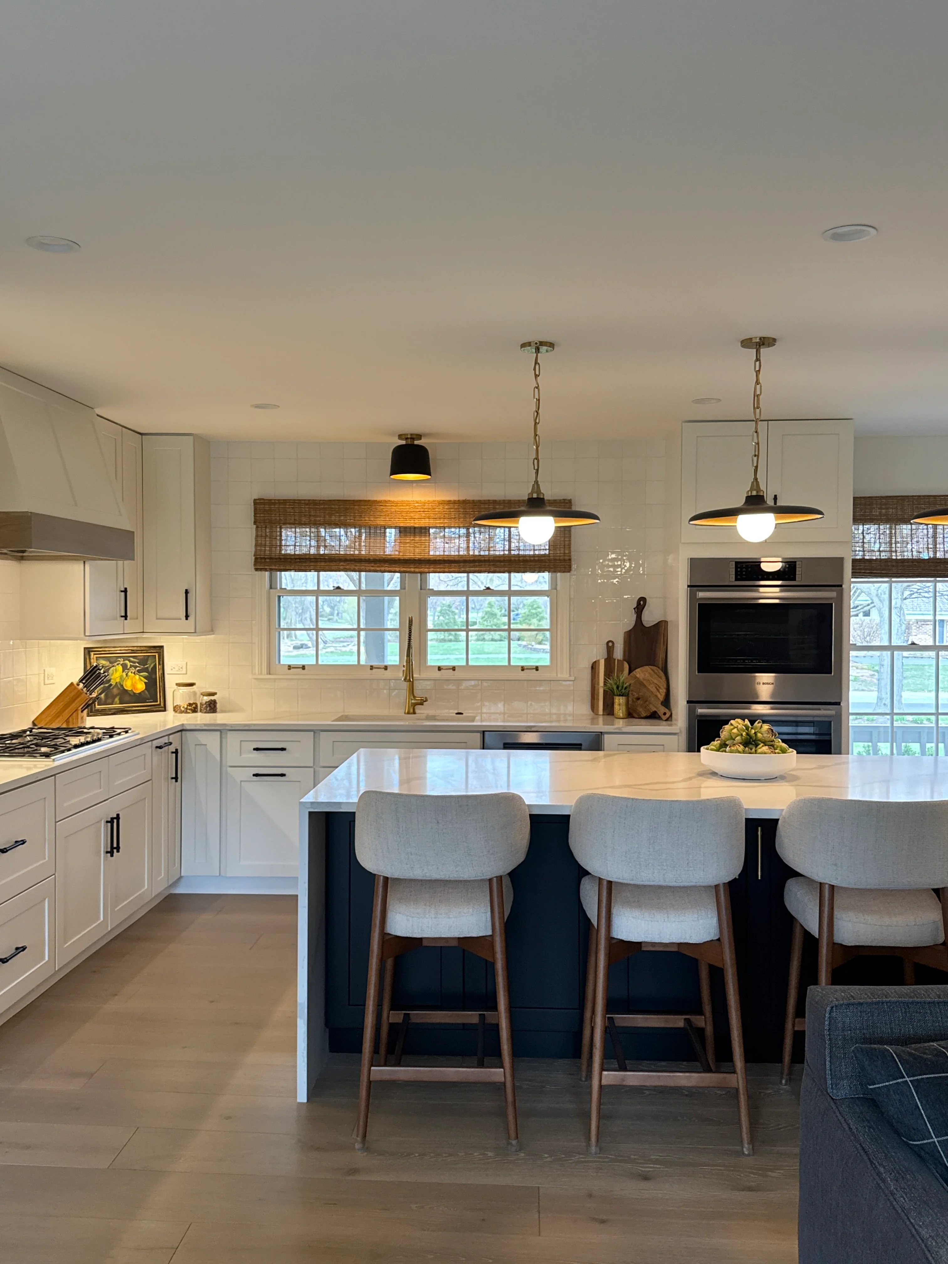 Modern kitchen with white cabinets, quartz countertops, island seating, and stainless steel appliances